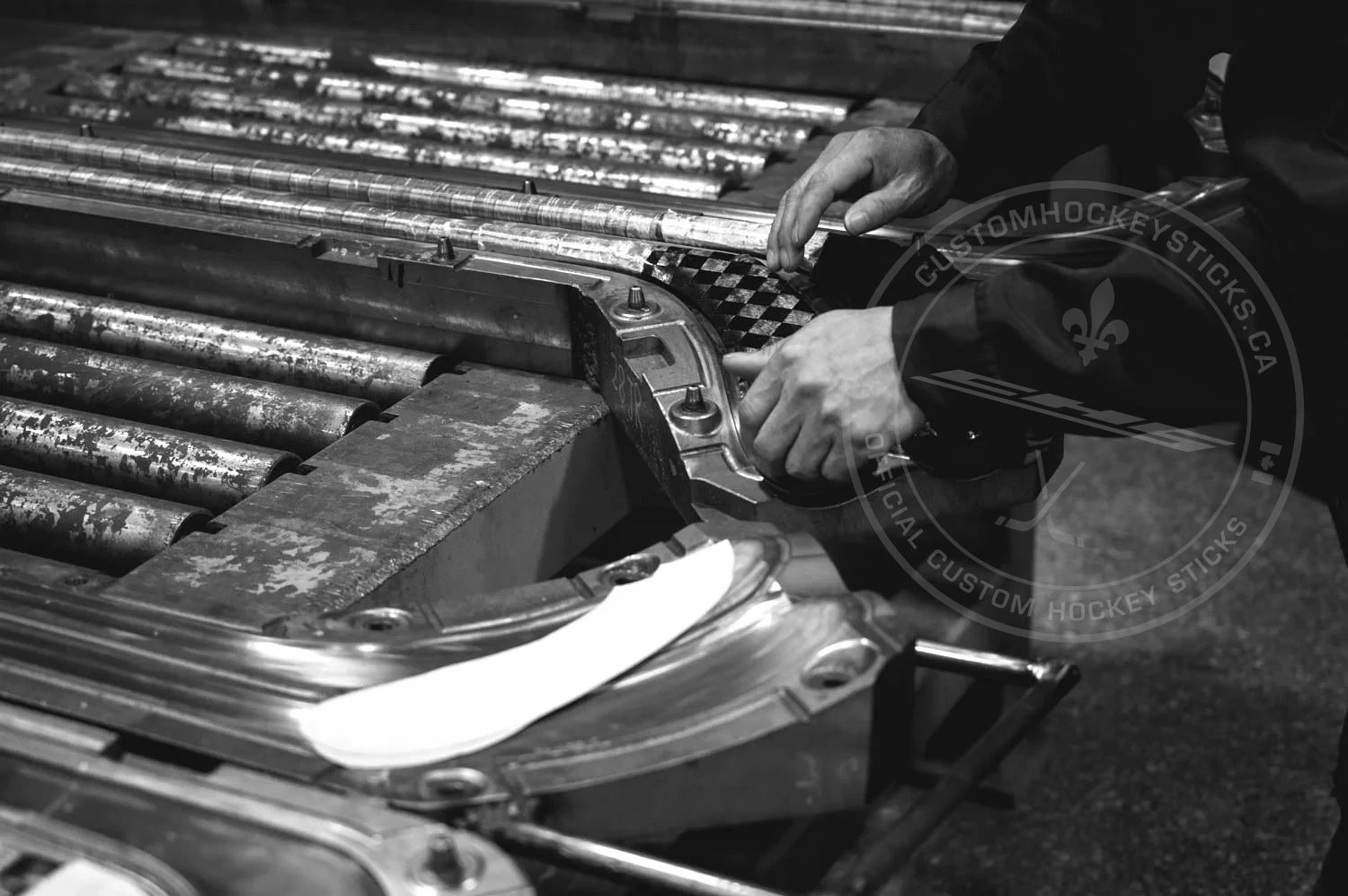 Person molding custom hockey stick in factory.